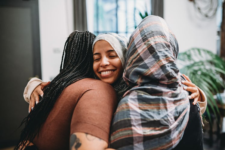 a group of friends embrace as they consider how the January 2024 Full Wolf Moon will affect 4 zodiac...