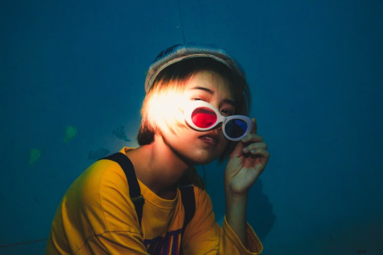 Sun Sign: Portrait Of Woman Wearing Sunglasses Against Wall