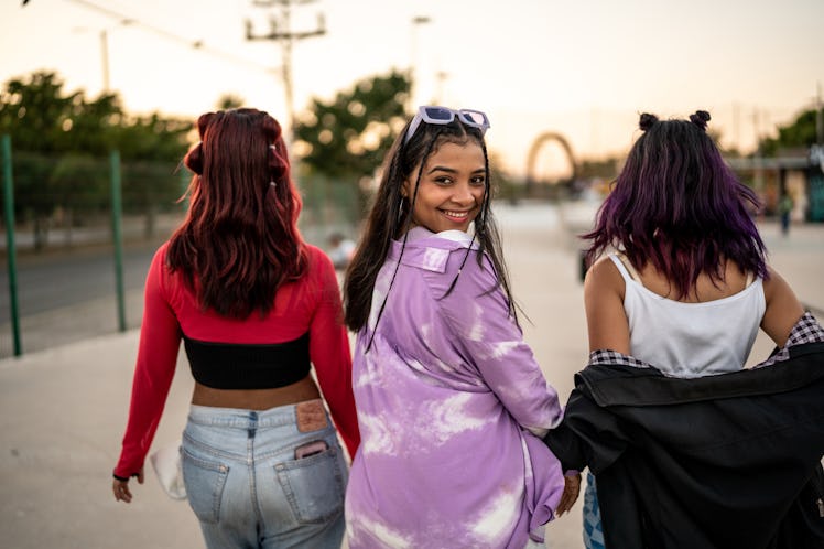 Young group of friends, with one girl turning to look over her shoulder during the South Node's late...